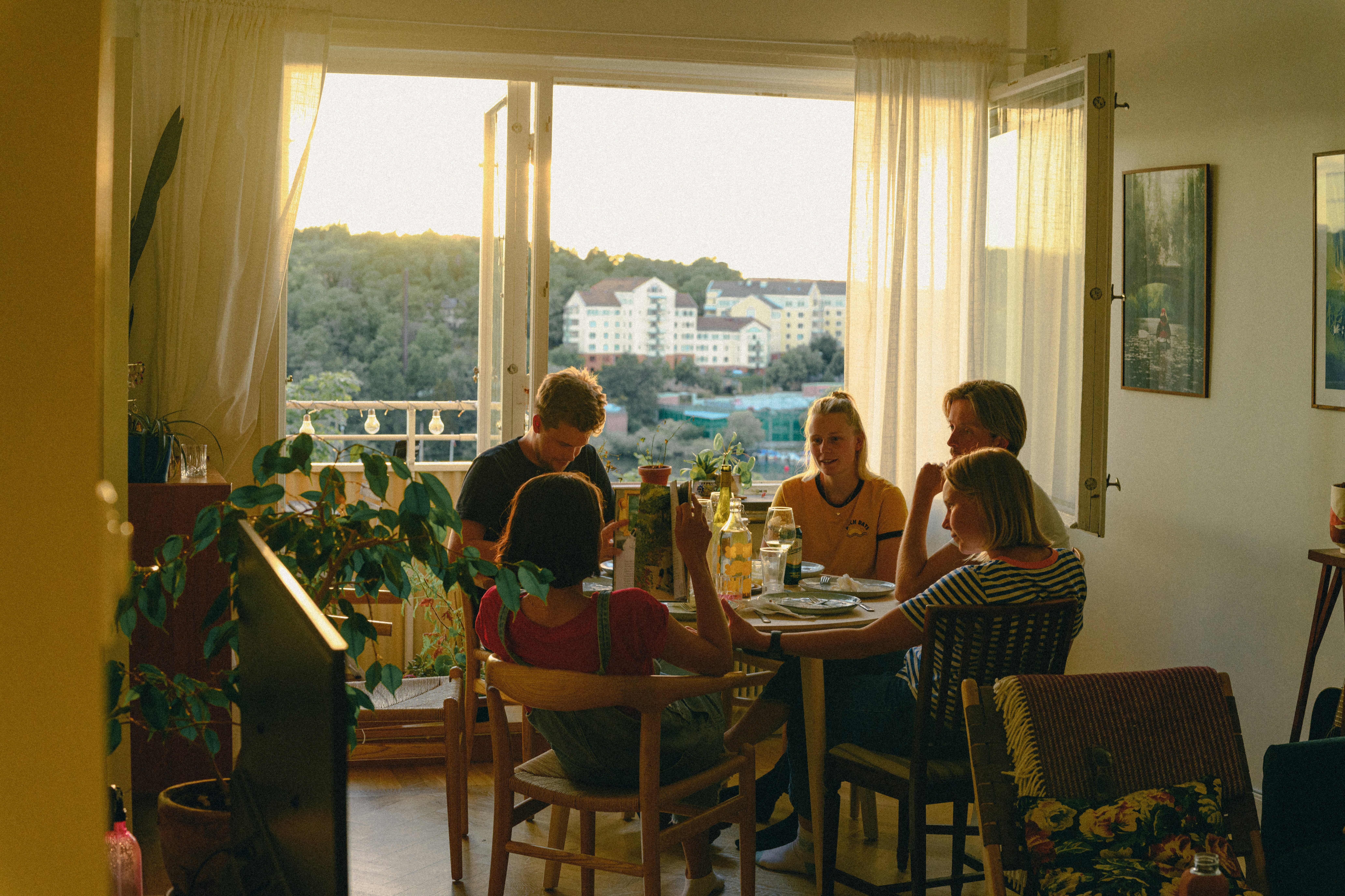 A person smiling while arranging plates on a beautifully set dinner table.